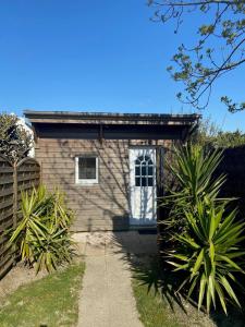 una casa con una puerta blanca y algunas plantas en Maisonnette proche plage Saint-Malo en Saint-Malo