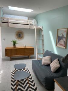 a living room with a couch and a bunk bed at Maisonnette proche plage Saint-Malo in Saint Malo