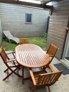 einen Holztisch und zwei Stühle sowie einen Tisch und Stühle in der Unterkunft Maisonnette proche plage Saint-Malo in Saint-Malo