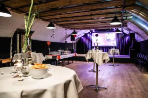 Herzogenbuchsee的住宿－黑措根布赫塞克魯澤酒店，一间设有白色桌子和紫色照明的用餐室