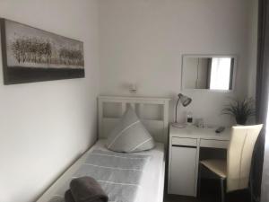 ein kleines Schlafzimmer mit einem Bett und einem Schreibtisch in der Unterkunft Hotellerie Gasthaus Schubert in Garbsen