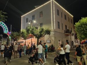 tłum ludzi idących nocą ulicą w obiekcie Le Stanze di Ricci - Affittacamere Low cost w mieście Lesina
