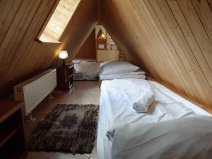 コシチェリスコにあるApartament Księżycowyのベッド2台と窓が備わる屋根裏部屋です。