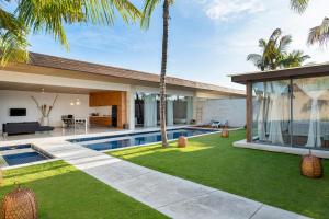 an exterior view of a house with a swimming pool and palm trees at One Eleven in Seminyak