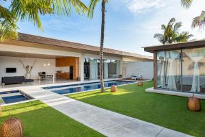 Vista exterior de una casa con piscina y palmeras. en One Eleven, en Seminyak