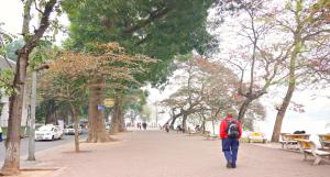 a man walking down a street with a backpack at Golden Sun Hotel Trendy in Hanoi