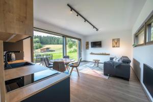 uma cozinha e sala de estar com um sofá e uma mesa em Modul Häuser Maurer em Georgenberg