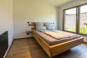 uma cama num quarto com uma grande janela em Modul Häuser Maurer em Georgenberg