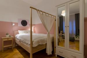 sypialnia z łóżkiem z baldachimem i lustrem w obiekcie Studio Next To Kiraly Street w Budapeszcie