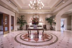 un gran vestíbulo con una mesa con flores. en The Sutton Place Hotel Vancouver en Vancouver