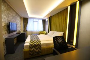 Habitación de hotel con cama y TV en GRAND DORA HOTEL, en Ankara