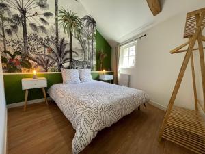 a bedroom with a bed with a painting on the wall at Appartement Le Voltaire centre ville climatisé in Saumur