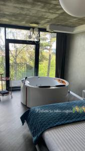 a large bath tub in a room with a window at Exclusive Jacuzzi Apartaments Klaipėda in Aukštkiemiai