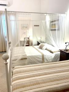 een slaapkamer met 2 bedden en klamboes bij B&B L'Assunta in Alessano