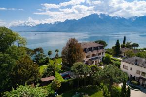 una vista aérea de una casa con un lago y montañas en Montreux Rotana Garden House with Private Pool - Swiss Hotel Apartments, en Montreux