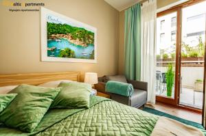 sypialnia z łóżkiem, krzesłem i oknem w obiekcie Baltic Apartments - Portofino w Świnoujściu