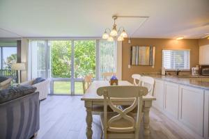 eine Küche und ein Wohnzimmer mit Tisch und Stühlen in der Unterkunft Island Beach Club #220C in Sanibel + 19 Fotos