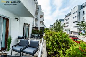 balkon z krzesłami i stołami na budynku w obiekcie Baltic Apartments - Portofino w Świnoujściu