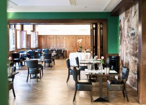 a dining room with tables and chairs and green walls at Romantik Hotel Barbarossa in Konstanz
