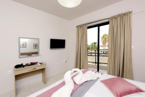 a bedroom with a bed and a desk and a window at Palm Square Appart in Ialysos