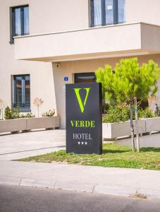 a sign for a hotel in front of a building at Hotel Verde in Podgorica
