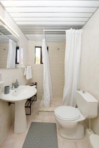 a bathroom with a white toilet and a sink at Palm Square Appart in Ialysos