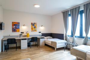 ein Krankenhauszimmer mit einem Schreibtisch und einem Bett in der Unterkunft Hotel Verde in Podgorica