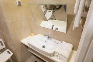 ein Badezimmer mit Waschbecken und Spiegel in der Unterkunft Hotel Verde in Podgorica + 29 Fotos