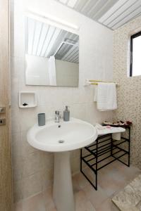 a white bathroom with a sink and a mirror at Palm Square Appart in Ialysos