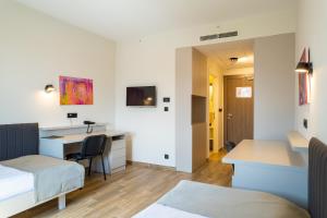 ein Zimmer mit einem Bett und einem Schreibtisch und einem Bett in der Unterkunft Hotel Verde in Podgorica