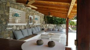 patio z kanapami i kamienną ścianą w obiekcie Skaloma Beach Estate w mieście Karaḯskos