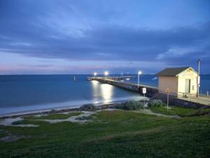 a pier with a building next to the water at night at St. Leonards Pier Beach House in Saint Leonards +20 photos