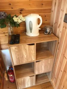 una estantería de madera con una jarra encima en unique sheperds hut ensuite & kitchenette, en Clodock