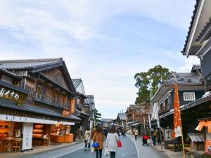 people walking down a street in an asian town at Hotel Castle Inn Ise in Ise