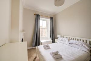 een slaapkamer met een bed met twee handdoeken erop bij GuestReady - Amazing apt near The Meadows in Edinburgh
