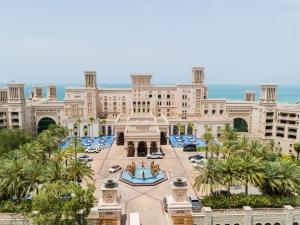 um grande edifício com palmeiras na frente em Jumeirah Al Qasr Dubai no Dubai