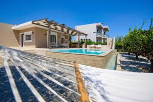 a hammock in front of a house with a swimming pool at Cypress View Boutique Villa in Asgourou