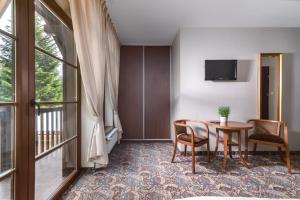 a hotel room with a table and chairs and a window at Osada Grzybowski Młyn in Grzybowski Młyn