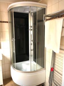 uma cabina de duche em vidro na casa de banho com uma toalha em Apartament Natura em Koszalin