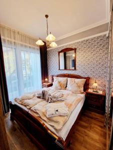 a bedroom with a large bed with a mirror on the wall at Spa Residence Carbona Aloe Lux Apartman Hévíz in Hévíz