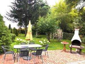 a patio with a table and chairs and a grill at Apartament Natura in Koszalin