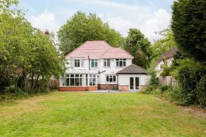 a white house with a red roof and a yard at Beautiful 6 bedroom house for 15 guests next to Edgbaston Stadium in Birmingham