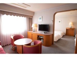 伊勢市にあるHotel Castle Inn Ise Meotoiwaのベッドとテレビが備わるホテルルームです。