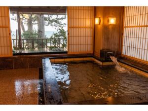 伊勢市にあるHotel Castle Inn Ise Meotoiwaの水のプールと窓が備わる客室です。