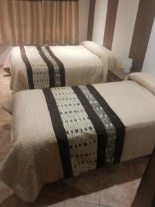 two beds sitting next to each other in a room at Hostal El Duende Blanco in Sierra Nevada