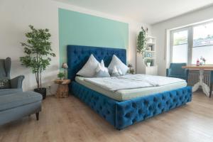 Una cama azul con cabecero azul en un dormitorio en Ferienwohnung BergPfote en Scheidegg