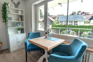 een eetkamer met een tafel en twee blauwe stoelen bij Ferienwohnung BergPfote in Scheidegg