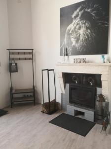 una sala de estar con chimenea y un león en la pared en Chez Alex et Sophie, en Louzac - Saint-André