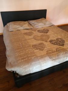 Una cama con una manta marrón encima. en Chez Alex et Sophie, en Louzac - Saint-André