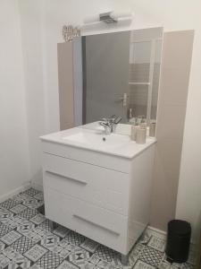 Baño blanco con lavabo y espejo en Chez Alex et Sophie, en Louzac - Saint-André